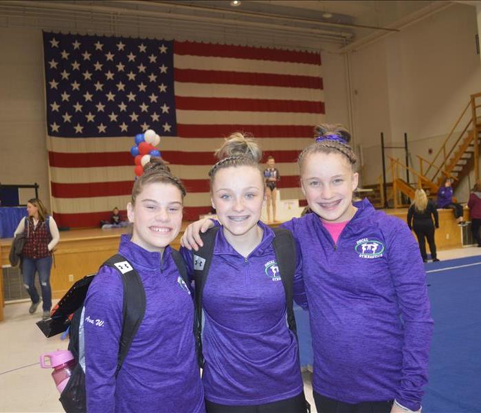 3 Gymnasts pose at Travis Mills Foundation Gymnastics Meet - SERVPRO of Augusta/Waterville Sponsored Event